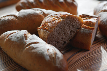 Freshly baked bread on bakery shelves. Bread diversity in bright light. Breads with a golden crust on wooden shelves