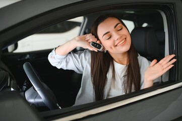 Young woman sitting in car holding keys