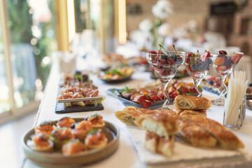 Wedding served banquet table with cold, hot appetizers. table with snacks, catering for a wedding. various snacks and drinks at the buffet table at the corporate catering event