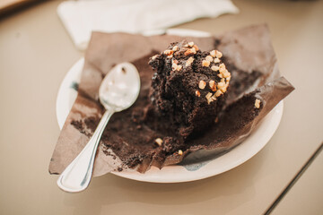 Close up and top view of eaten chocolate muffin cake with dirty spoon.