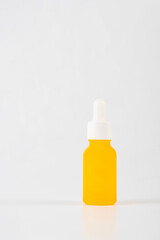 Yellow glass cosmetic bottle, Skin care or sunscreen cosmetic on white background.