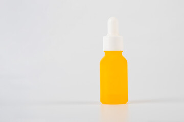 Yellow glass cosmetic bottle, Skin care or sunscreen cosmetic on white background.