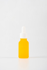 Yellow glass cosmetic bottle, Skin care or sunscreen cosmetic on white background.