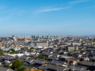 古い日本家屋が建ち並ぶ住宅地と都会の風景