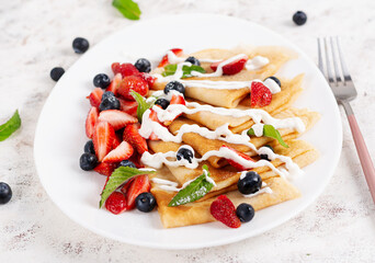 Pancakes with berries and sour cream. Healthy breakfast. Late breakfast. Crepes