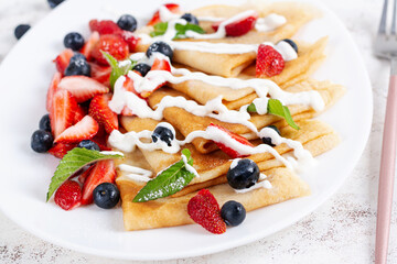 Pancakes with berries and sour cream. Healthy breakfast. Late breakfast. Crepes