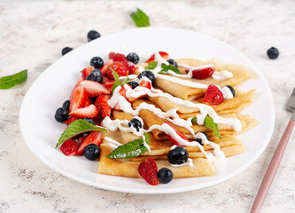 Pancakes with berries and sour cream. Healthy breakfast. Late breakfast. Crepes