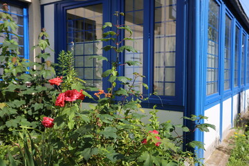 Véranda bleue avec parterre de fleurs