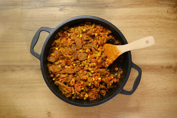 Overhead view of beef and vegetables ragout on wooden countertop