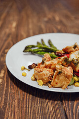 Close-up view of spicy chicken ragout with vegetables and fried asparagus