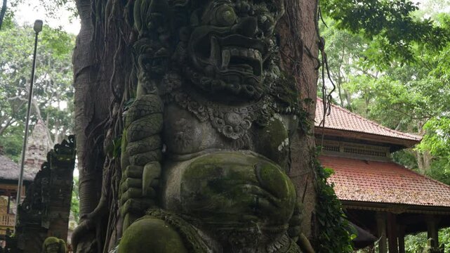 Moss-covered Sculpture By The Tree At Sacred Monkey Forest Sanctuary In Bali, Indonesia. closeup, ascending shot