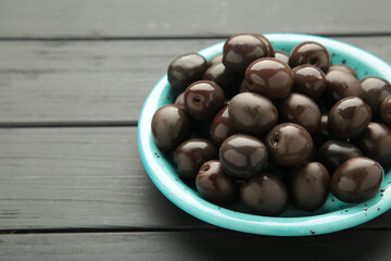 Blue bowl of pickled black olives, top view