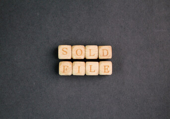 wooden cube with the word sold file. the concept is sold