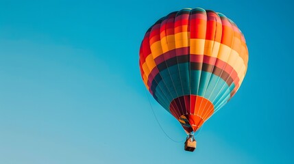Naklejka premium Striped colors hot air balloon flying on blue sky. 