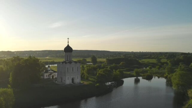 drone flight at dawn around the Orthodox Church of the Intercession of the Blessed Virgin Mary on the Nerl River, Bogolyubovo, Suzdal district, Vladimir region, Russia. High-quality 4k footage