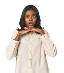 Portrait of a young Indian woman praying for luck, amazed and opening mouth looking to front.