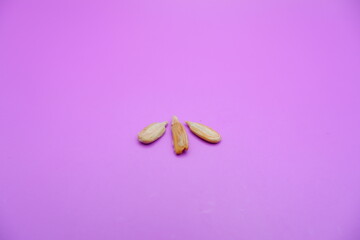 peeled sunflower seeds snack isolated on a purple background
