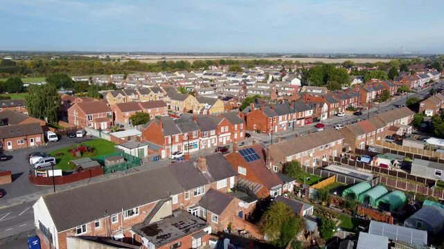 Aerial drone footage of a British house with solar panels on the roof, on a sunny summers day in the city of Doncaster in Yorkshire in the summer time