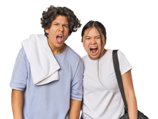 Young interracial athletic couple in studio screaming very angry and aggressive.