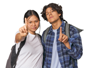 Young interracial student couple studying showing number one with finger.