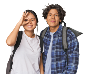 Young interracial student couple studying excited keeping ok gesture on eye.