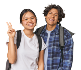 Young interracial student couple studying joyful and carefree showing a peace symbol with fingers.
