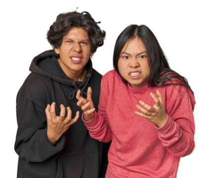 Young interracial couple in studio upset screaming with tense hands.