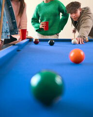 Close Up Of Group Of Teenage Girls And Boys At Home Playing Game Of Pool Together