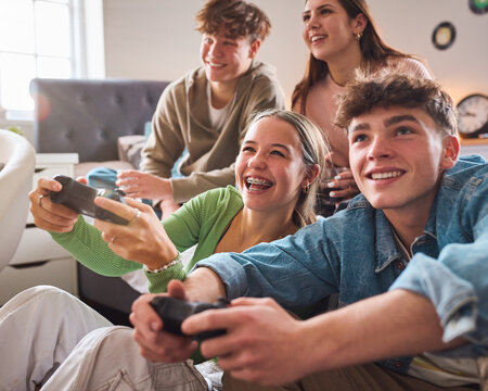 Close Up Of Teenage Girls And Boys At Home In Bedroom Together Playing Computer Games Together