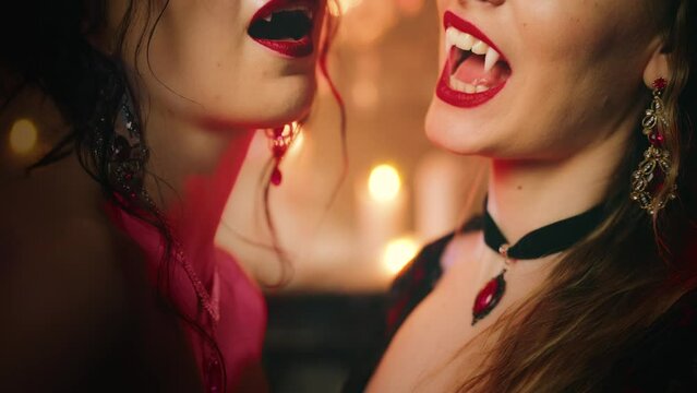 Two Fantasy women smiling face waving hands gesture of invitation to carnival costume theme party night club creative design black red dress. Happy girl vampire evil woman sexy lips show fangs art 4k