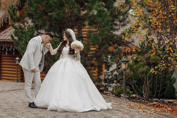 Fototapeta premium A bride and groom are standing on a brick walkway, the bride wearing a white dress and the groom wearing a suit