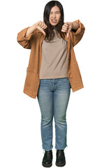 Full-body young Chinese woman showing thumb down and expressing dislike.