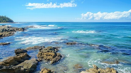 Beautiful beach rocks with blue water and clear sky with waves on a sunny summer day.