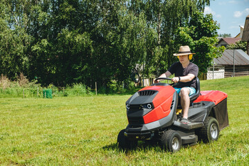 Man on lawn tractor mowing lawn on backyard. The red rider. The lawnmower tractor. High quality 4k footage