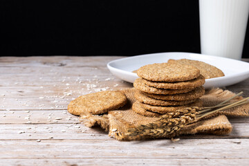 Healthy oatmeal cookies and milks on wooden table. Copy space