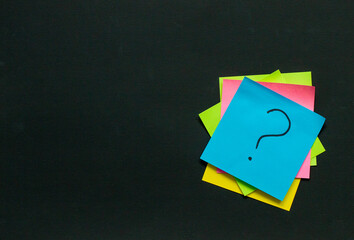 stack of stickers with questions on a black board, questions and idea concept