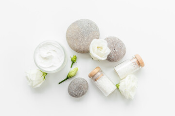 Layout of white cosmetics products and roses flowers, top view
