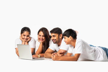 Fototapeta premium Indian asian young family with parents and kids using computer while sitting isolated on white