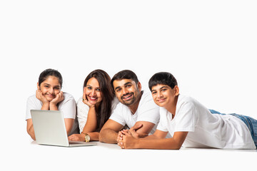 Indian asian young family with parents and kids using computer while sitting isolated on white