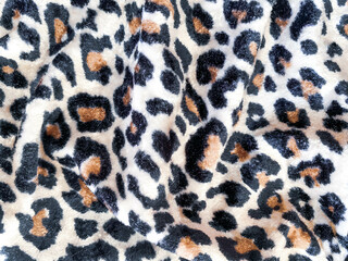 Textile background. Fabric with a leopard print, velvety, and velvet-like.  Cheetah velvet fabric. 