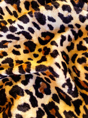 Textile background. Fabric with a leopard print, velvety, and velvet-like.  Cheetah velvet fabric. 