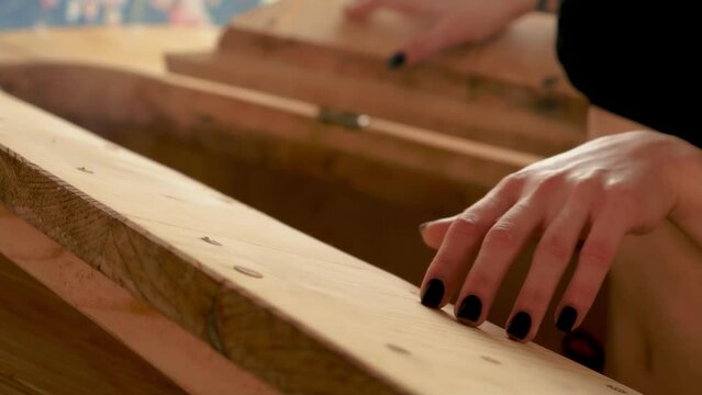 Client girl runs her hand over wooden phyto barrel and enjoys beginning of procedure and evaporating aroma of medicinal herbs. Wooden phyto barrel, bench is installed inside it, on which person sits