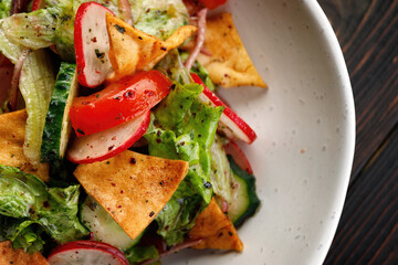 salad featuring fresh vegetables and crispy chips, on a Wooden Background