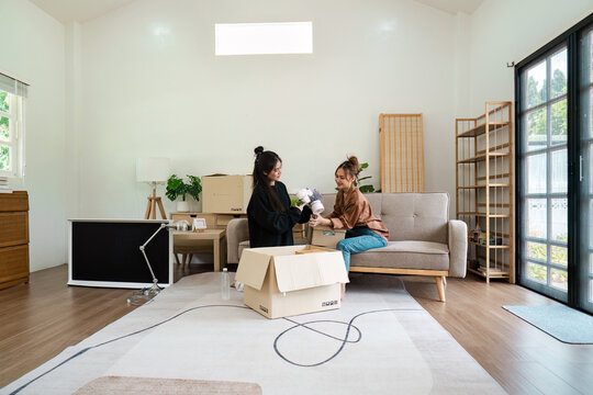 Lesbian Couple Moving into New Home, Unpacking Boxes, and Decorating Living Room - LGBT Family Starting New Life Together