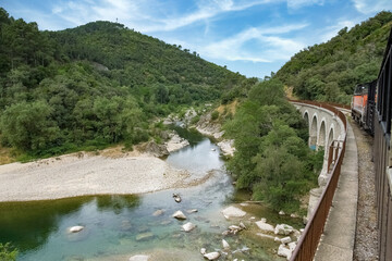 The steam train of the Cevennes, old train in a french landscape, on the river
