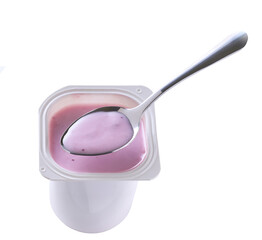 Open packing with blueberry yoghurt in a white plastic cup with a spoon isolated on a white background. Top view.
