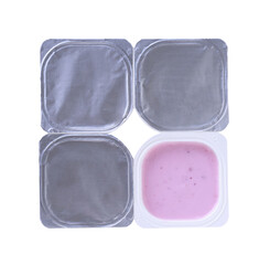 Four plastic containers for blueberry yogurt with foil lid, isolated on white background . Top view.