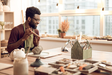 African american sculptor conducting a n online tutorial and looking contented