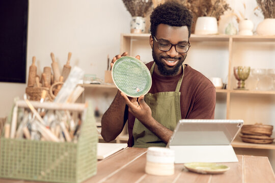 African american sculptor conducting a n online tutorial and looking contented