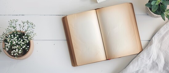 An open book with empty pages placed on a clean desk with a white background for a copy space image.